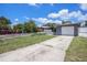 Charming home featuring a one-car garage, a long driveway, a well-kept yard, and a classic white picket fence at 702 Regent S Cir, Brandon, FL 33511