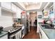 Galley kitchen featuring stainless steel appliances, white cabinets, and dark wood flooring at 702 Regent S Cir, Brandon, FL 33511