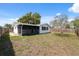 Backyard featuring lawn and view of the white home's screened in porch at 7123 Cherry Laurel Dr, Port Richey, FL 34668