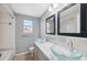 Bathroom featuring double sink with clear glass basins and framed mirrors at 7123 Cherry Laurel Dr, Port Richey, FL 34668