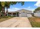 Beautiful single-story home with a white exterior, an attached garage, and well-manicured front yard at 7123 Cherry Laurel Dr, Port Richey, FL 34668