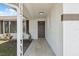 Inviting front porch with neutral tile, leading to a freshly painted front door, and manicured landscaping at 7123 Cherry Laurel Dr, Port Richey, FL 34668