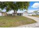 Charming single-story home with an attached garage, a well-kept lawn, and mature trees offering ample shade at 7123 Cherry Laurel Dr, Port Richey, FL 34668