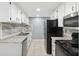 Efficient kitchen layout with white cabinets, stainless steel appliances, and a stylish tile backsplash at 7123 Cherry Laurel Dr, Port Richey, FL 34668