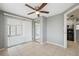 This living room includes tile flooring, a ceiling fan, a closet with mirrored doors, and access to the kitchen at 7123 Cherry Laurel Dr, Port Richey, FL 34668