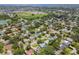 An aerial view of a residential neighborhood with mature landscaping, a baseball field, and a pond at 734 Lake Forest Rd, Clearwater, FL 33765