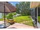 Spacious backyard with a patio area, lush green lawn, and a variety of plants and trees at 734 Lake Forest Rd, Clearwater, FL 33765
