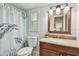 Cozy bathroom featuring a turtle-themed shower curtain, a vanity, and a window with plantation shutters at 734 Lake Forest Rd, Clearwater, FL 33765