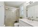 Bright bathroom featuring glass-enclosed shower, neutral tile, and modern vanity at 734 Lake Forest Rd, Clearwater, FL 33765