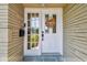 Inviting front door with decorative wreath and sidelight, complemented by a brick facade and slate entryway at 734 Lake Forest Rd, Clearwater, FL 33765