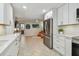 Bright kitchen with stainless steel appliances, white cabinets, and a view to an adjacent Gathering room at 734 Lake Forest Rd, Clearwater, FL 33765