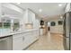 Bright kitchen features modern white cabinets, stainless steel appliances, granite countertops, and an open layout at 734 Lake Forest Rd, Clearwater, FL 33765