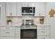 Bright kitchen features white cabinets, stainless steel appliances, and white marble countertops at 734 Lake Forest Rd, Clearwater, FL 33765