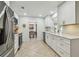Modern kitchen with stainless steel appliances, white cabinets, stone countertops, and ample counter space at 734 Lake Forest Rd, Clearwater, FL 33765