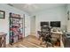 Comfortable home office with a ceiling fan, desk, and shelves stocked with books and games at 734 Lake Forest Rd, Clearwater, FL 33765