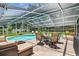 Outdoor seating area and landscaping surrounds the screened in pool at 734 Lake Forest Rd, Clearwater, FL 33765