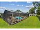 Inviting screened-in pool area with lounge chairs and a dining table, perfect for outdoor entertaining at 734 Lake Forest Rd, Clearwater, FL 33765