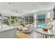 Bright sunroom with tile floors and a view of the screened in pool and backyard at 734 Lake Forest Rd, Clearwater, FL 33765