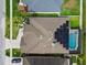 Aerial view of a single Gathering home with solar panels and screened-in pool at 7410 Ambleside Dr, Land O Lakes, FL 34637