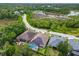 Aerial view of a single Gathering home with solar panels, screened-in pool, and wooded surroundings at 7410 Ambleside Dr, Land O Lakes, FL 34637