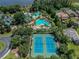 An aerial view shows tennis courts and swimming pools at a beautiful community at 7410 Ambleside Dr, Land O Lakes, FL 34637