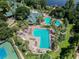 An aerial view showcases resort-style pools and palm trees at a beautiful community at 7410 Ambleside Dr, Land O Lakes, FL 34637