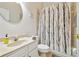 A bathroom features a vanity, toilet, and shower with a decorative tree-themed curtain at 7410 Ambleside Dr, Land O Lakes, FL 34637