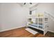 A cozy bedroom with a white bunk bed, hardwood floors, and natural light at 7410 Ambleside Dr, Land O Lakes, FL 34637