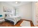 Bright bedroom with hardwood floors, a queen bed, and an adjacent bathroom at 7410 Ambleside Dr, Land O Lakes, FL 34637