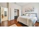 Bedroom featuring wood floors, closet, queen bed, and access to other rooms at 7410 Ambleside Dr, Land O Lakes, FL 34637