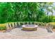 Cozy fire pit area with seating, perfect for outdoor gatherings surrounded by lush trees at 7410 Ambleside Dr, Land O Lakes, FL 34637