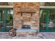Outdoor stone fireplace with mantle, flanked by doors leading to outdoor spaces, perfect for gatherings at 7410 Ambleside Dr, Land O Lakes, FL 34637