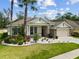 Beautiful single Gathering home with manicured lawn and stone accents, lush tropical landscaping and a two-car garage at 7410 Ambleside Dr, Land O Lakes, FL 34637