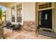 Covered front porch with stone accents, seating area, and a welcoming entrance at 7410 Ambleside Dr, Land O Lakes, FL 34637