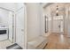 Bright hallway with tile floors, a bench, and access to a laundry room at 7410 Ambleside Dr, Land O Lakes, FL 34637