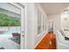 Hallway leading to the patio area shows wood floors and a view of the screened in pool at 7410 Ambleside Dr, Land O Lakes, FL 34637