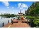 Dock with kayaks in still lake waters surrounded by lush greenery and a clear sky at 7410 Ambleside Dr, Land O Lakes, FL 34637