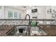 Kitchen sink area with granite countertops and a view of the living room at 7410 Ambleside Dr, Land O Lakes, FL 34637