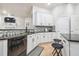 Kitchen featuring granite countertops, stainless steel appliances, white cabinets and a breakfast bar at 7410 Ambleside Dr, Land O Lakes, FL 34637