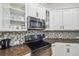 A close up of a kitchen with white cabinets and granite counters at 7410 Ambleside Dr, Land O Lakes, FL 34637