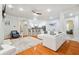 Open living area with hardwood floors, a white sectional, kitchen bar seating, and lots of natural light at 7410 Ambleside Dr, Land O Lakes, FL 34637