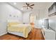 Bright main bedroom features hardwood floors, a ceiling fan, and an en-suite bathroom entrance at 7410 Ambleside Dr, Land O Lakes, FL 34637