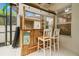 Outdoor tiki bar features two white barstools, bamboo accents, a fun 