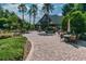 Community clubhouse patio with lush landscaping, umbrella tables and chairs, and an inviting walkway at 7410 Ambleside Dr, Land O Lakes, FL 34637