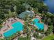 Stunning aerial view of a community pool area with palm trees and lounge chairs at 7410 Ambleside Dr, Land O Lakes, FL 34637