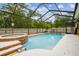 Screened in backyard pool and spa with waterfall feature at 7410 Ambleside Dr, Land O Lakes, FL 34637