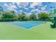 Well-maintained tennis court surrounded by trees, offering a great recreational space at 7410 Ambleside Dr, Land O Lakes, FL 34637