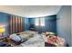 Comfortable bedroom with blue walls, rug, curtains and a window for natural light at 7415 San Moritz Dr, Port Richey, FL 34668