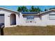 Close up front exterior of single-story home featuring stucco and solar panels at 7415 San Moritz Dr, Port Richey, FL 34668