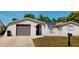Single-story home featuring a stucco exterior, solar panels, a single car garage, and a front yard at 7415 San Moritz Dr, Port Richey, FL 34668